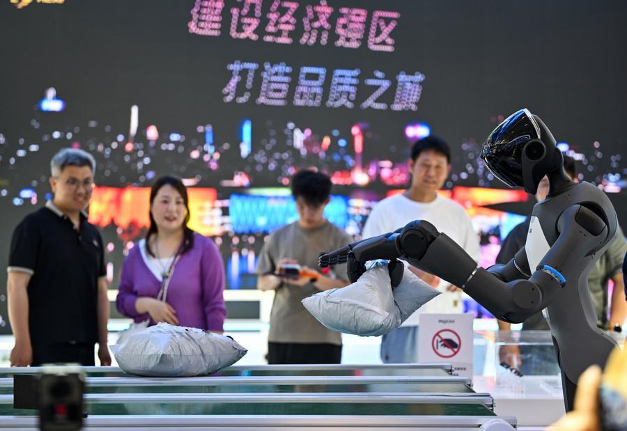 Pessoas observam um robô humanoide demonstrando suas funções na Expo Mundial de Inteligência 2026 em Tianjin, no norte da China, em 28 de maio de 2026. (Xinhua/Zhao Zishuo)