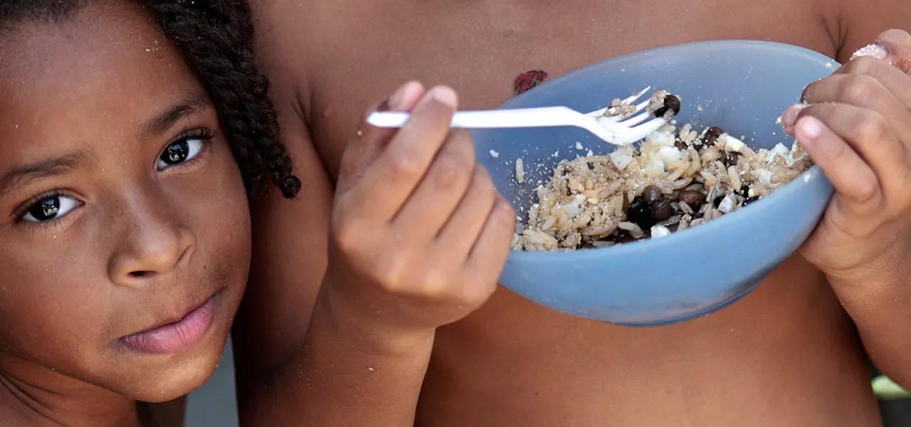 Thawanny Silva de Souza, de 6 anos, (E) e Rafael Silva de Souza, de 9 anos, (D), comem prato com arroz, feijão e ovo na Favela do Arci-Íris, em Recife 15/09/2022