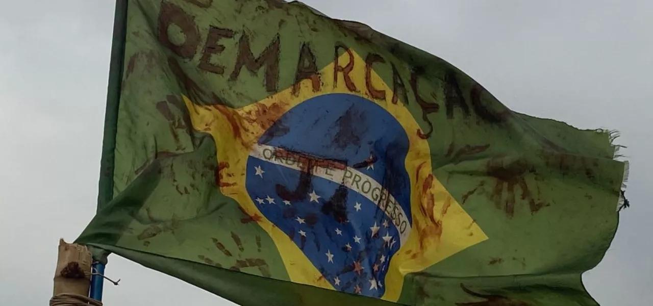 Bandeira nacional fincada na retomada Yvy Ajere, Terra Indígena Lagoa Panambi. Comunidade Guarani e Kaiowá segue sob ataque