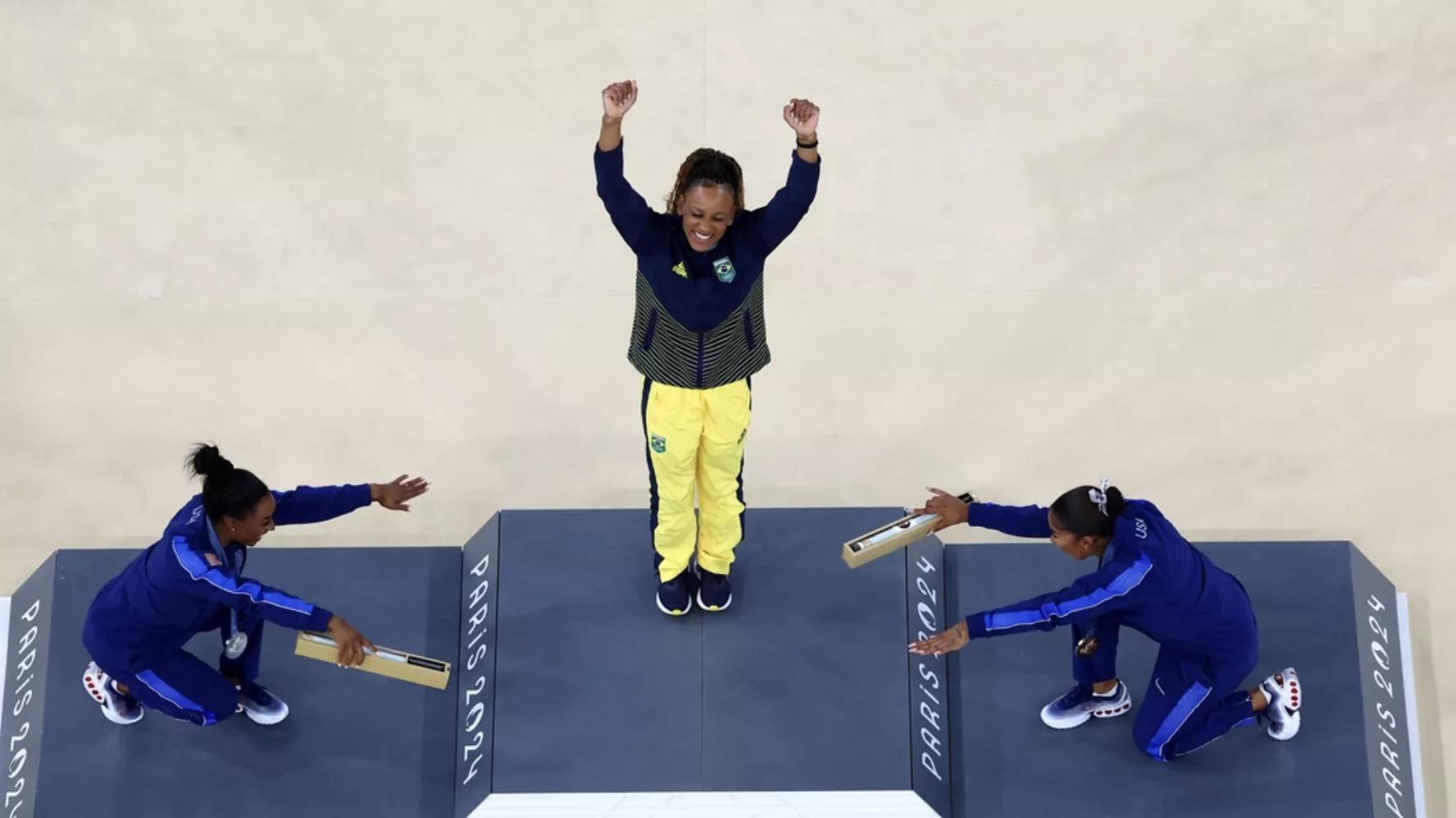 A medalhista de ouro Rebeca Andrade, do Brasil, comemora com a medalhista de prata Simone Biles, dos Estados Unidos, e a medalhista de bronze Jordan Chiles, dos Estados Unidos, no pódio
